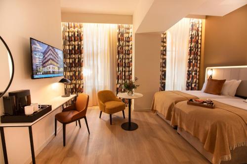 a hotel room with a bed and a desk and a television at The Address Glasgow in Glasgow