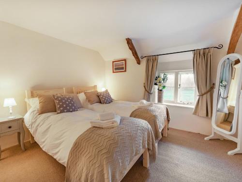 a bedroom with two beds and a mirror at 2 Bed in South Molton 86611 in Dennington