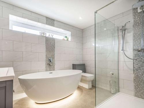a white bathroom with a tub and a toilet at 2 bed property in Bradford-on-Avon 87056 in Southwick