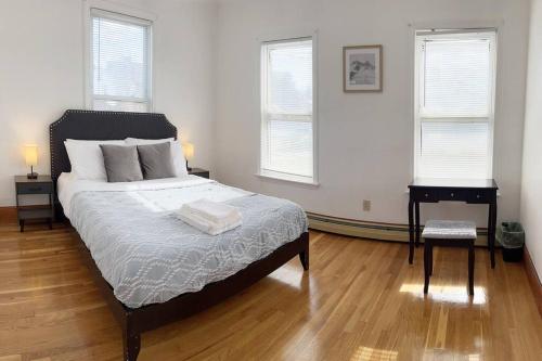 a bedroom with a large bed and two windows at 17 Cozy&Spacious 3 bedroom home in Malden in Malden