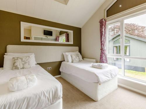2 Bed in Ilfracombe 87360 في Kentisbury: سريرين في غرفة مع نافذة