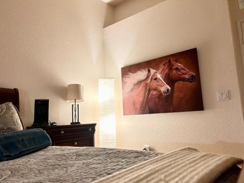 a bedroom with a painting of two horses on the wall at Countryside Colt Suite with private bathroom in Hemet