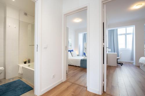 een badkamer met een spiegel en een slaapkamer met een bed bij BmyGuest - Boa Hora Apartment in Lissabon