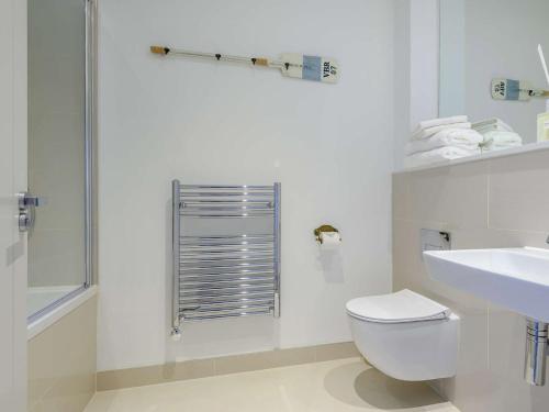 een witte badkamer met een toilet en een wastafel bij 2 Bed in Porthcawl 87294 in Porthcawl