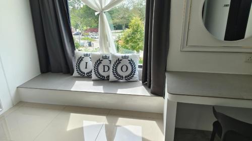 a window with two pillows sitting on a window sill at I Do Farmstay in Bukit Mertajam