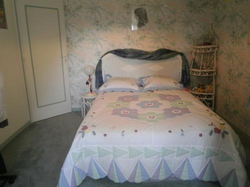 1 dormitorio con 1 cama en una habitación con papel pintado en 2 Chambres chez l habitant, en Parigné-lʼÉvêque