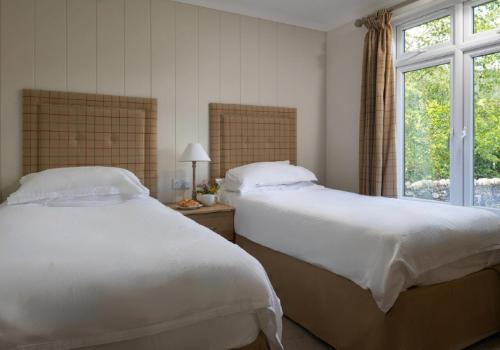 - une chambre avec 2 lits et une fenêtre dans l'établissement Llyn Dinas Lodge, à Betws-y-coed