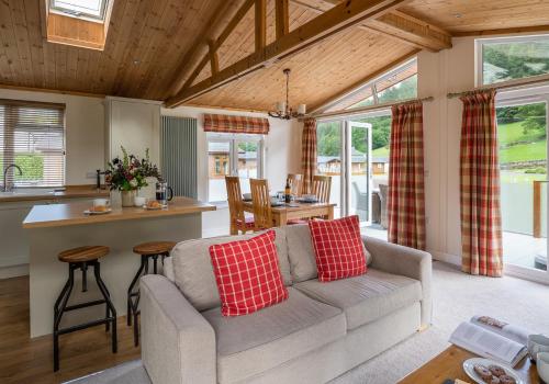 a living room with a couch and a table at Llyn Dinas Lodge in Betws-y-coed
