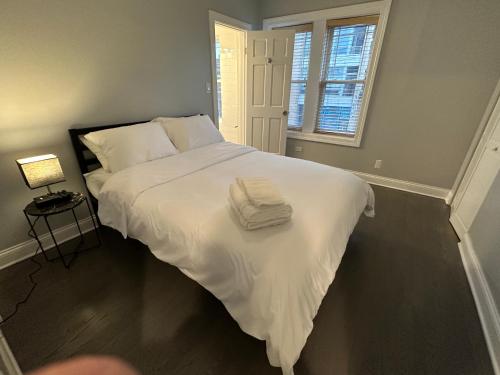 a white bed with two towels on it in a bedroom at Spacious Wicker Park Hideaway with Parking! in Chicago