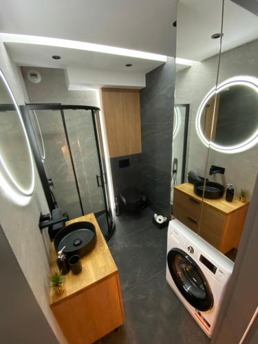Beautiful Apartment Tarasy Wiślane Free GARAGE في كراكوف: حمام صغير مع حوض ومرآة