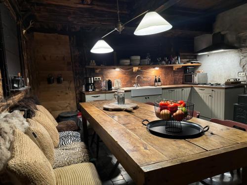 a kitchen with a wooden table with a bowl of fruit on it at Warm and Stylish Boutique Lodge L'Etoile de Savoie in Abondance