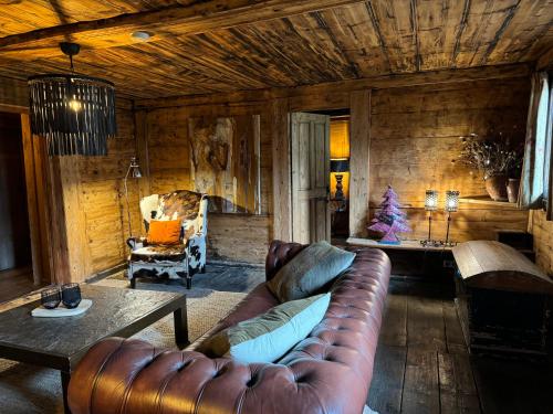 a living room with a leather couch and a table at Warm and Stylish Boutique Lodge L'Etoile de Savoie in Abondance