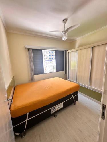 - une chambre avec un lit dans une pièce dotée d'une fenêtre dans l'établissement Apartamento Temporada Guarujá, à Guarujá