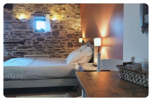 a bedroom with a bed and a stone wall at la Ferme de Vazerat in Massiac