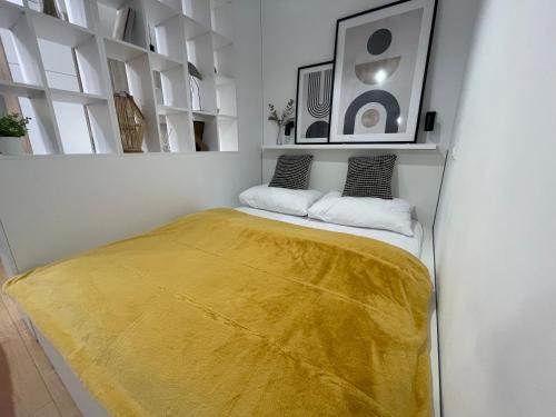 1 dormitorio con 1 cama con manta amarilla en Rainbow Apartments Premium CENTRUM, en Kielce