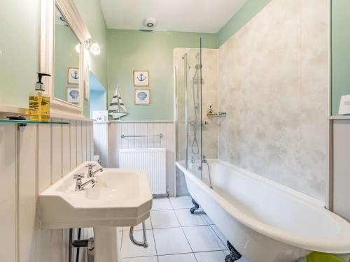 a bathroom with a tub and a sink and a bath tub at Peaseblossom House, a charming Grade II Listed Building, in a great location in Alnwick in Alnwick