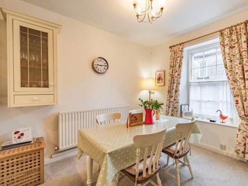 a dining room with a table and chairs and a clock at Peaseblossom House, a charming Grade II Listed Building, in a great location in Alnwick in Alnwick