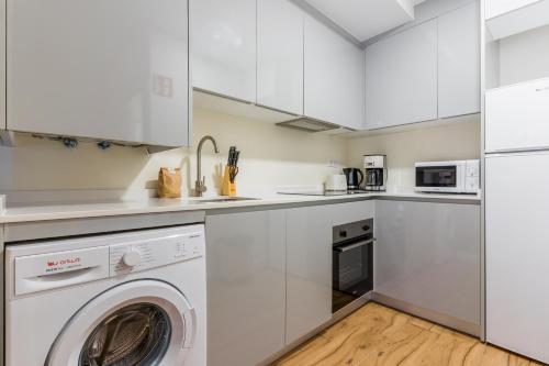 馬德里的住宿－Bright and cozy- 1D 1B- Plaza Castilla，厨房配有白色橱柜、洗衣机和烘干机