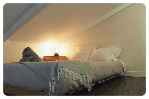 a bedroom with a bed and a night stand with a lamp at la Ferme de Vazerat in Massiac
