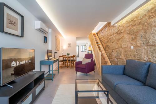 een woonkamer met een bank en een tv bij Charming Stylish House w Mezzanine and Terrace in Porto