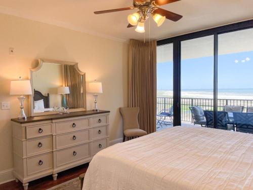 a bedroom with a bed and a dresser with a mirror at 507 Holiday Isle 507 in Dauphin Island