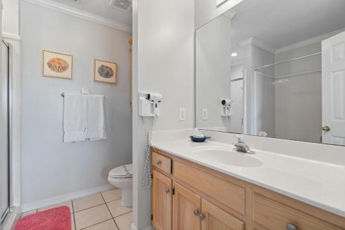 a white bathroom with a sink and a toilet at 019 Sandcastle 4D in Dauphin Island