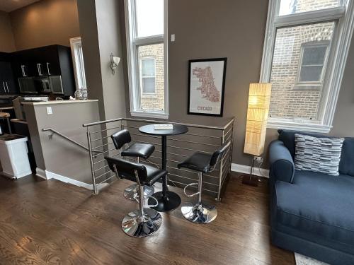 uma sala de estar com uma mesa e cadeiras e um sofá em Wrigley Penthouse with Private Roof Deck and Parking em Chicago