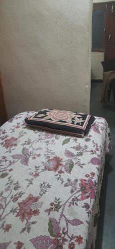 a bed with a flowered blanket on top of it at Comfy Living in Hyderabad