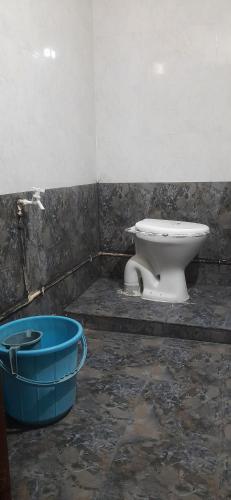 een badkamer met een toilet en een blauwe emmer bij Comfy Living in Hyderabad