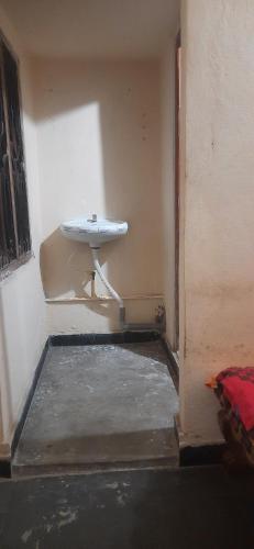 een badkamer met een wastafel in de hoek van een kamer bij Comfy Living in Hyderabad