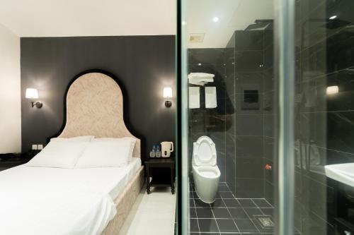 a bedroom with a bed and a shower and a toilet at Khách sạn Gấu Hotel in Hanoi