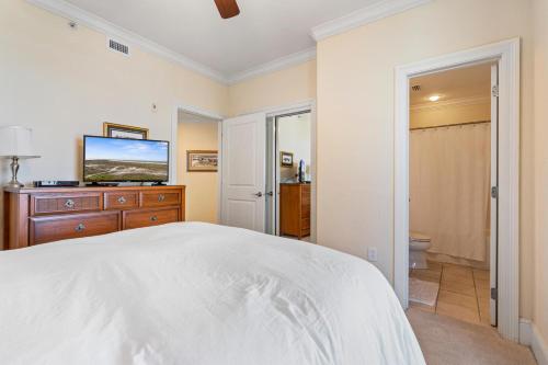 a white bedroom with a bed and a television at 701 Holiday Isle 701 in Dauphin Island