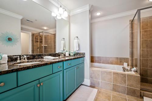 a bathroom with two sinks and a shower and a tub at 520 Holiday Isle 520 in Dauphin Island