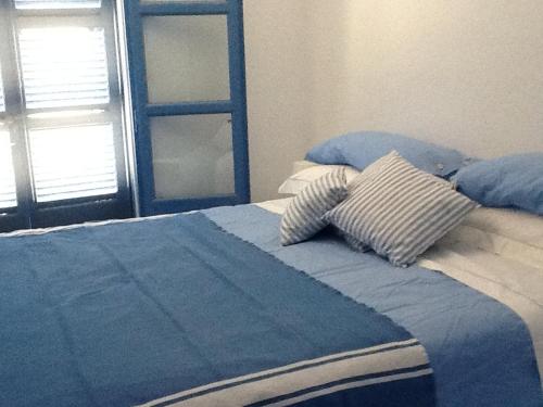 - un lit bleu avec 2 oreillers au-dessus dans l'établissement casa koklakura, à Lipsi