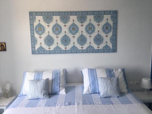 a bedroom with a bed with blue and white pillows at casa koklakura in Leipsoi