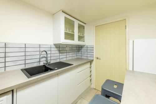 a kitchen with white cabinets and a sink and a toilet at Centralised Admiralty Terrace with FREE PARKING by Prescott Apartments in Bristol