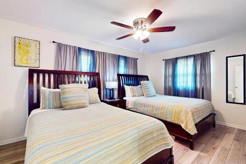 a bedroom with two beds and a ceiling fan at Relax in Retro in Clearwater