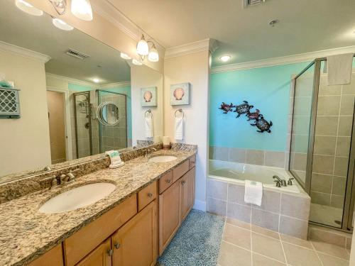 ein Badezimmer mit 2 Waschbecken, einer Dusche und einer Badewanne in der Unterkunft 604 Holiday Isle Beach Life in Dauphin Island