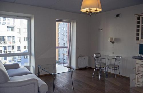 ein Wohnzimmer mit einem Sofa und einem Tisch mit Stühlen in der Unterkunft Real appartment in Vilnius