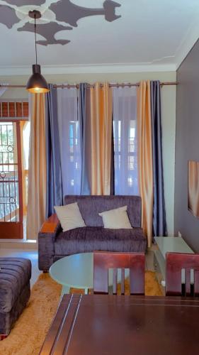 een woonkamer met een bank en een tafel bij Kamel Furnished Apartments! in Wakiso