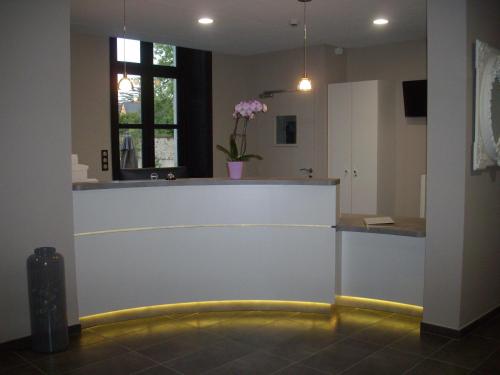 a lobby with a counter with a yellow hose at Hôtel Le Saint Martin in Sablé-sur-Sarthe