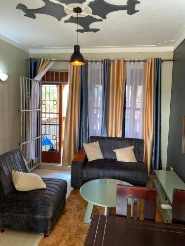 een woonkamer met een bank en een tafel bij Kamel Furnished Apartments! in Wakiso