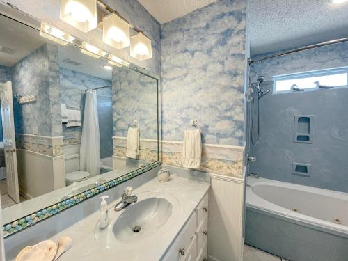 ドーフィン・アイランドにある051 Topsailの洗面台、鏡、浴槽のあるバスルーム