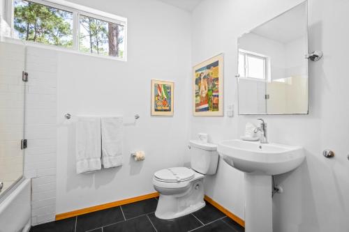 a white bathroom with a toilet and a sink at 055 Bough House in Dauphin Island