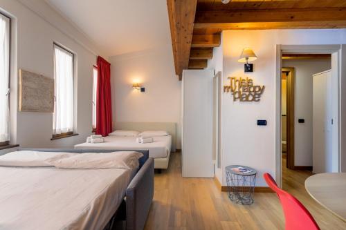 a hotel room with two beds and a table at Gressoney Saint-Jean apartments by Halldis in Gressoney-Saint-Jean