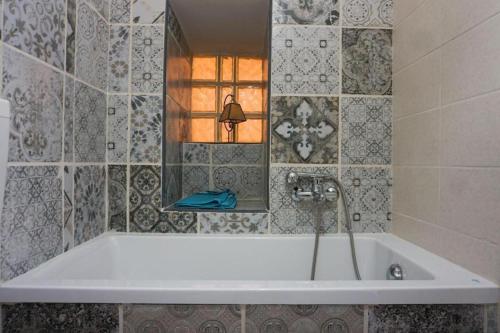 uma banheira com torneira na casa de banho em Blue Courtyard HOWME em Bari