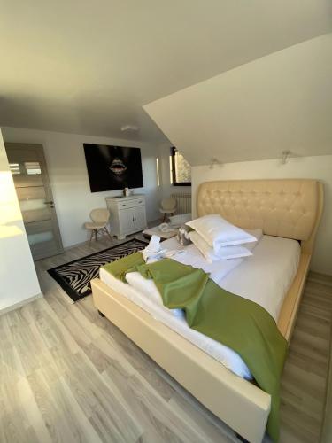a bedroom with a large bed with white sheets at VILA RAISA in Neagra Şarului