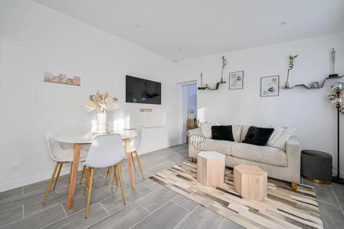 a living room with a table and a couch at La parenthèse in Claye-Souilly