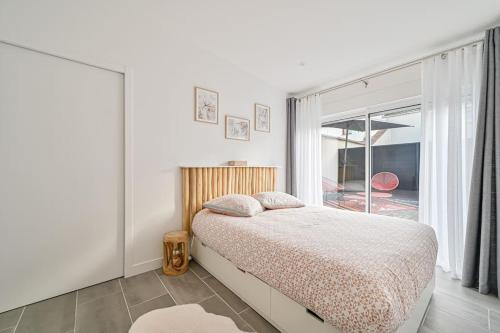 a bedroom with a bed and a large window at La parenthèse in Claye-Souilly