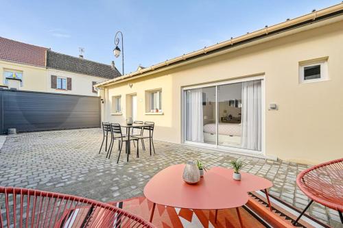 a patio with a red table and chairs at La parenthèse in Claye-Souilly